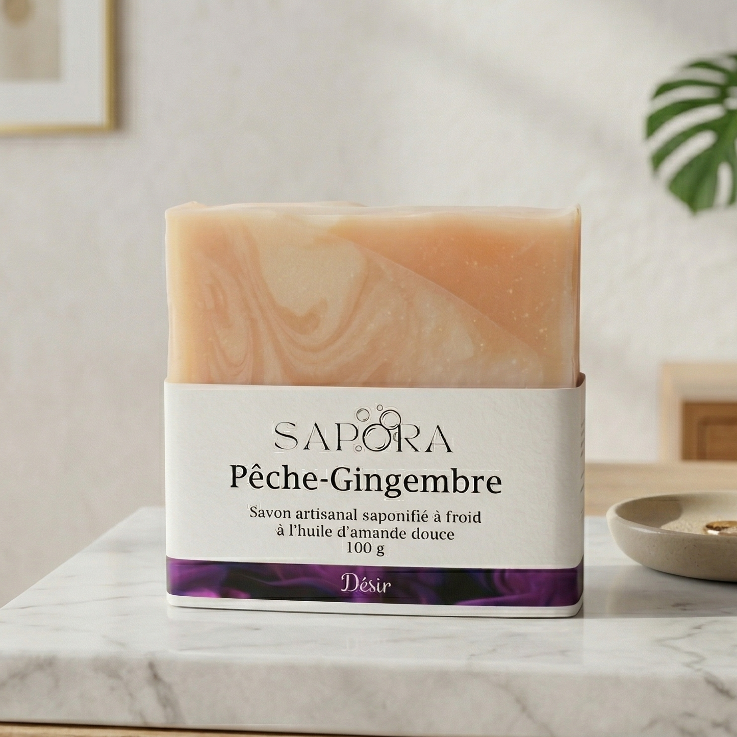 Savon artisanal Sapora Pêche-Gingembre à l'huile d'amande douce, posé sur un comptoir en marbre blanc dans un décor minimaliste et chic.