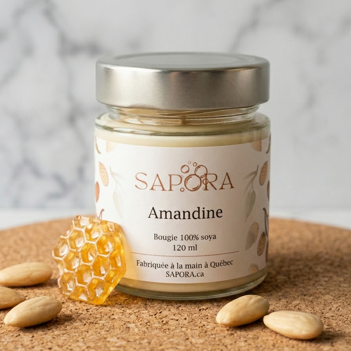 Bougie de soya artisanale Sapora Amandine au parfum d'amande et miel dans un décor épuré avec rayon de miel et amandes fraîches.