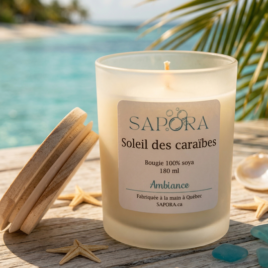 Bougie de soya Sapora Soleil des Caraïbes dans un pot givré sur une table en bois rustique avec décor de plage, étoiles de mer et mer turquoise en arrière-plan.