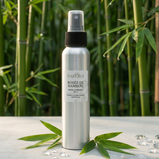 Bouteille de brume d'ambiance Rosée de Bambou de SAPORA en aluminium, présentée sur une surface blanche minimaliste avec des feuilles de bambou et des gouttes de rosée devant une forêt de bambous floue.