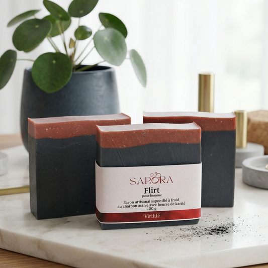 Savon artisanal pour homme Flirt de Sapora au charbon activé et beurre de karité, design moderne noir et rouge brique sur un plateau en marbre chic.