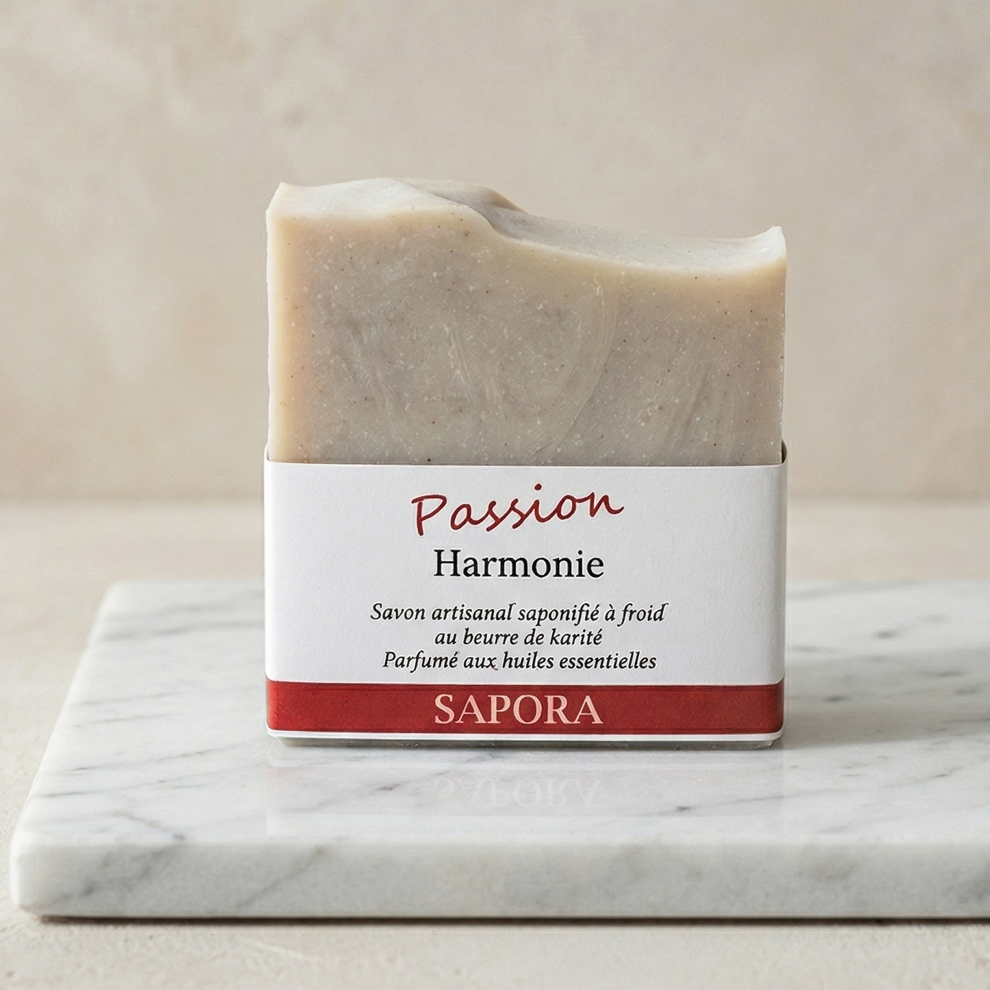 Savon artisanal saponifié à froid au beurre de karité Passion Harmonie de la marque Sapora, présenté sur un socle en marbre blanc dans un style minimaliste et chic.