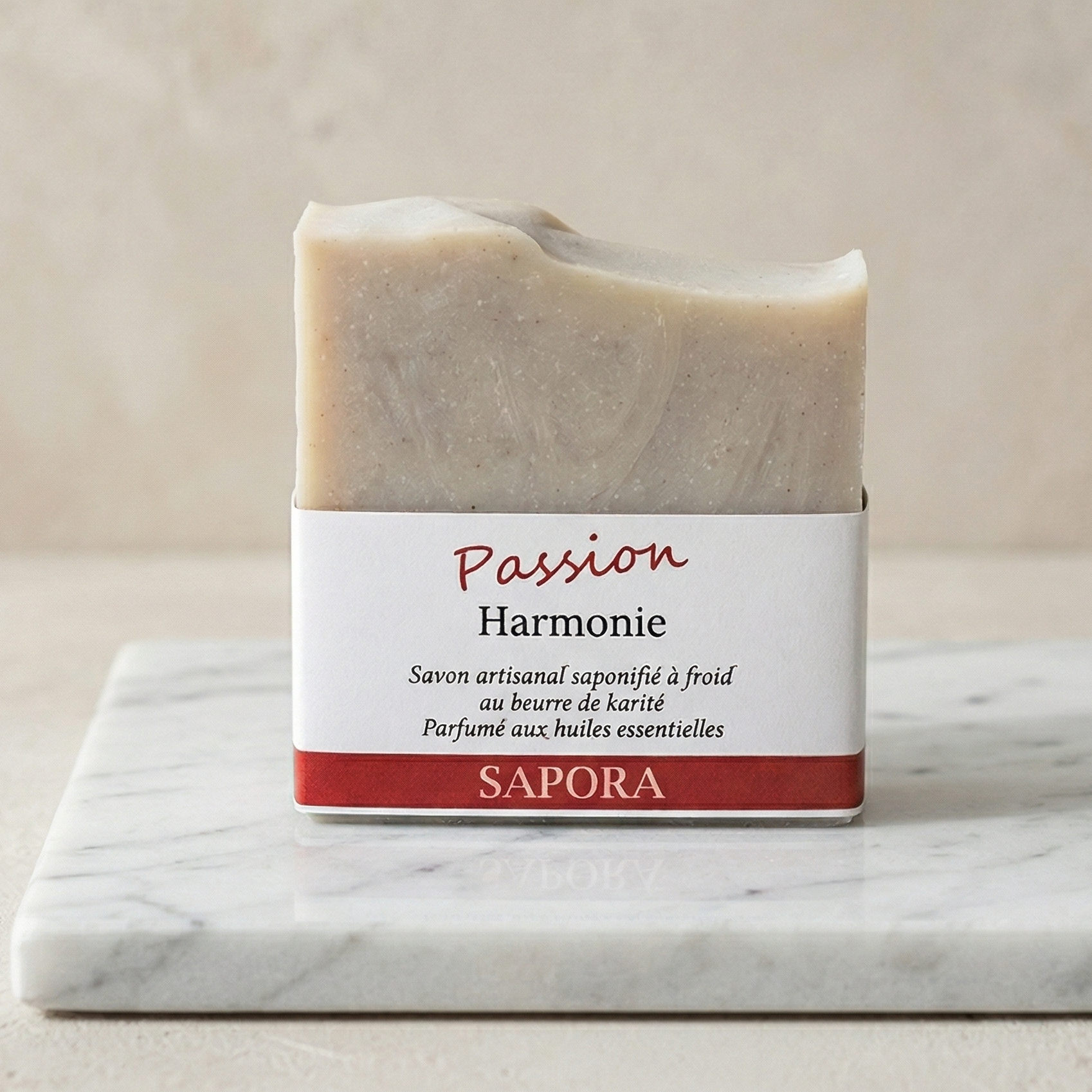 Savon artisanal saponifié à froid au beurre de karité Passion Harmonie de la marque Sapora, présenté sur un socle en marbre blanc dans un style minimaliste et chic.