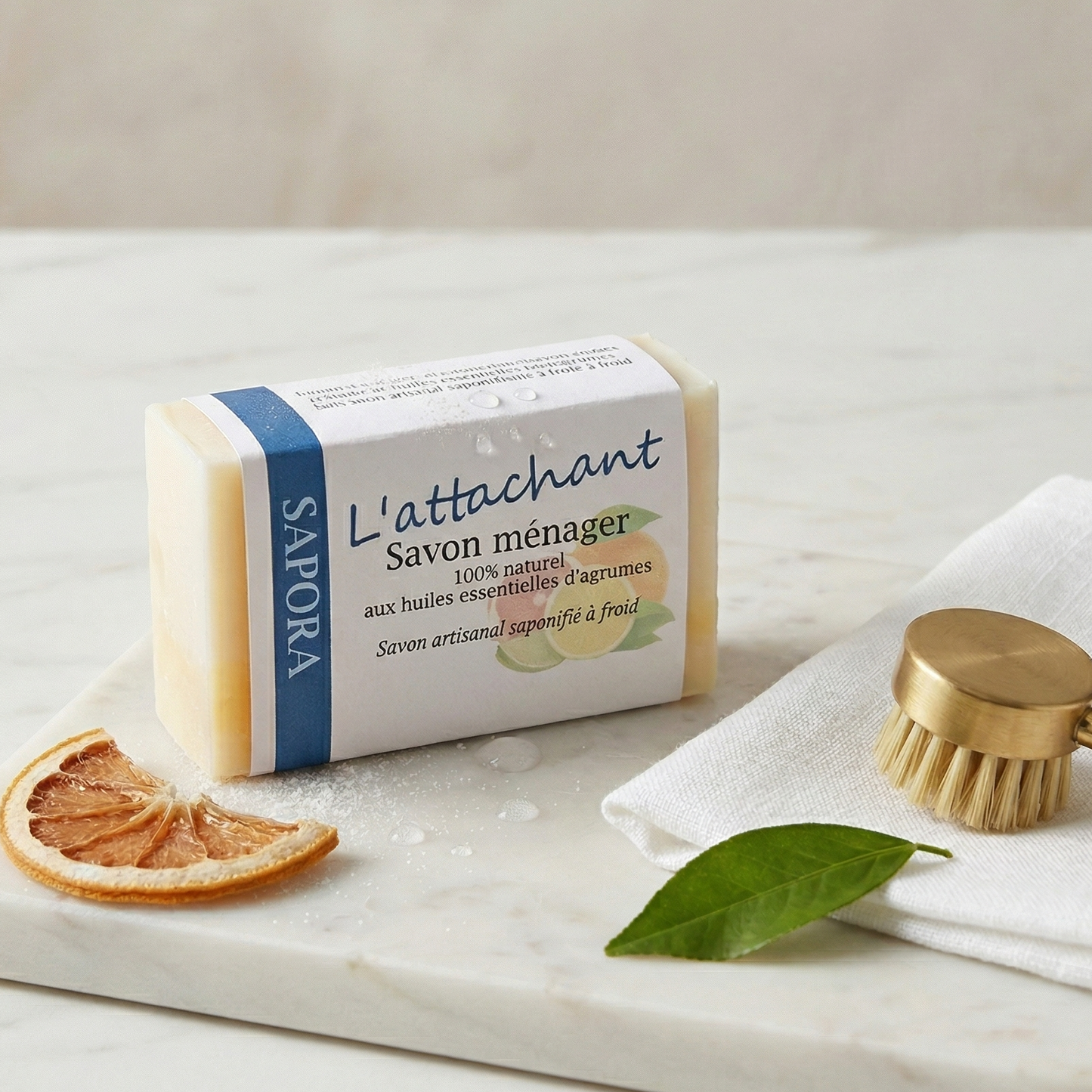 Savon ménager détachant artisanal aux agrumes, barre de savon solide pour vêtements et tissus, naturel et écologique, présenté dans un décor de buanderie minimaliste.